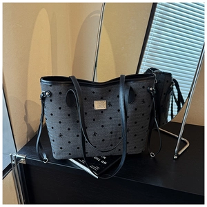 Detail of grey denim tote bag with black polka dots and embroidered bow patterns