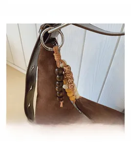 Detail of dark brown suede bag featuring vintage ethnic beads and silver ring connector