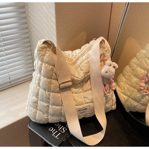Detail of quilted puffer tote bag with adjustable strap and plush bunny keychain