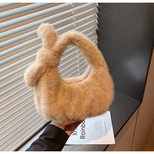 Dettaglio ravvicinato della borsa di peluche beige con un esclusivo manico a nodo