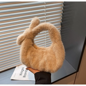 Gros plan détaillé d'un sac à main en fausse fourrure beige avec poignées rondes