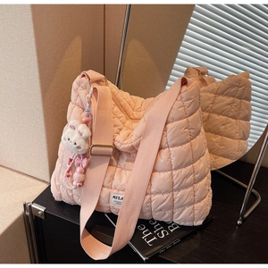 Detailed side view of pink quilted puffer tote bag with cute rabbit plush keychain