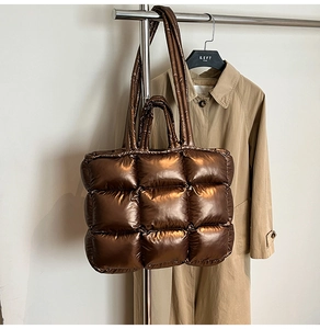 Macro shot of metallic brown quilted tote bag with puffer grid texture and double straps