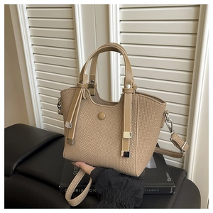 Detail of khaki woven bucket bag showing textured pattern and silver metal hardware