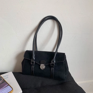Detail of black suede shoulder bag featuring white contrast stitching and silver twist lock