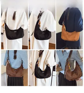 Detail view of suede crescent bags with vintage wooden beads in black, brown, and khaki