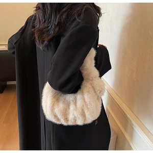 Dettaglio della borsa in peluche beige morbido con design a pieghe invernali