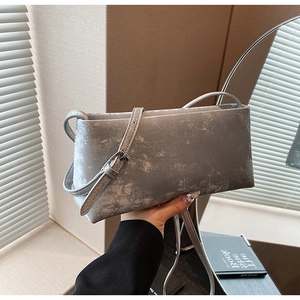 Detail of silver metallic retro underarm bag with adjustable strap and buckle closure