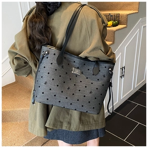 Detailed view of grey polka dot tote bag with bow embroidery and silver logo plate