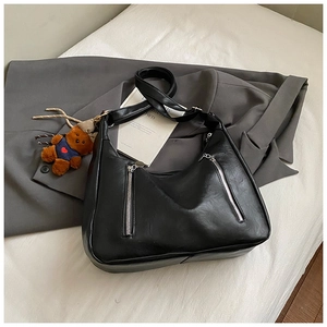 Detail view of black PU leather hobo bag with silver zippers and teddy bear charm
