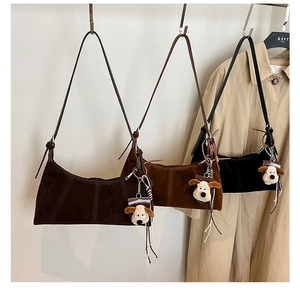 Detailed display of three vintage crescent bags in dark brown, caramel, and black faux suede