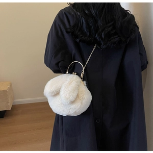 Detail der weißen Plüschtasche in Hasenform mit Metallgriff und feiner Schulterkette
