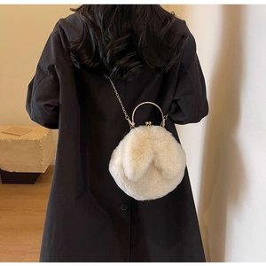 Rückansicht eines Models mit weißer Plüschtasche mit Hasenohren und Goldgriffen