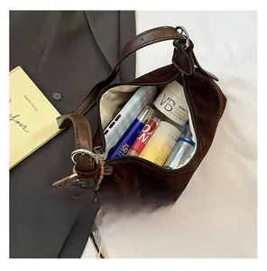 Deep brown suede crescent bag interior showing large capacity for cosmetics and phone