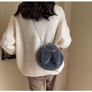 Sac lapin en peluche grise avec oreilles longues et chaîne dorée porté par modèle