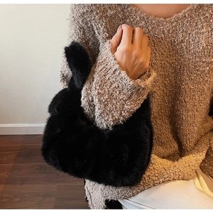 Vue détaillée d'un sac à main noir en peluche de luxe avec une texture de fausse fourrure