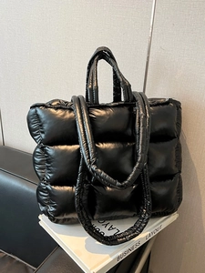 Fashionable black puffer tote bag with quilted nylon texture and shoulder strap