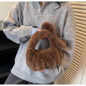 Dettaglio borsa in peluche marrone scuro con manico annodato per la moda invernale