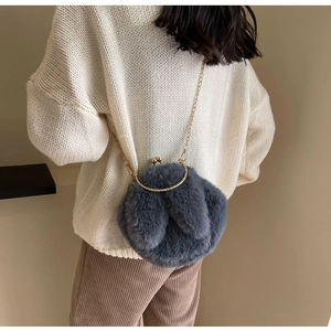 Sac seau en peluche grise avec oreilles de lapin et chaîne dorée porté par un modèle