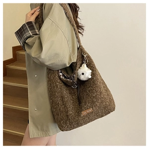Macro shot of brown fluffy fleece tote bag texture with leather patch and plush charm
