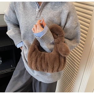Dettaglio borsa di peluche marrone caffè con trama a pieghe e ciondolo a pompon