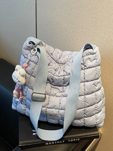 Quilted light blue tote bag with puffer texture and cute bunny plush charm detail