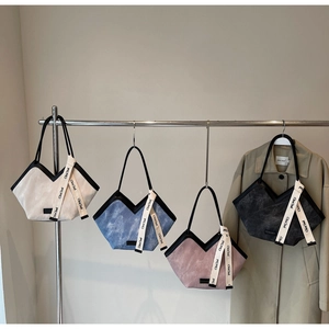 Detail of corduroy tote bags in four colors with V-shaped opening and black leather trim