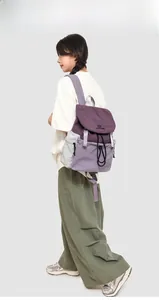 Detailed view of tricolor nylon backpack with purple tones and drawstring closure