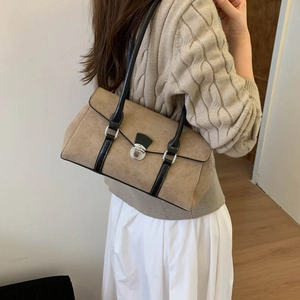 Detail of khaki suede shoulder bag featuring black leather straps and silver twist lock