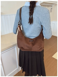 Detailed close-up of brown faux suede hobo bag with vintage textured finish and wooden beads