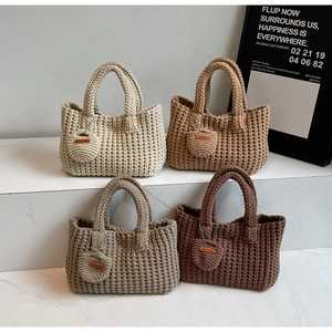 Gros plan de sacs seaux crochetés à la main avec pochettes cœur et étiquettes en cuir