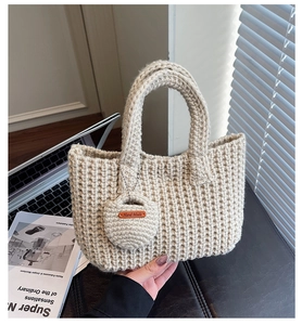Détail d'un sac à main beige en maille épaisse avec étiquette cuir 'Hand Made'