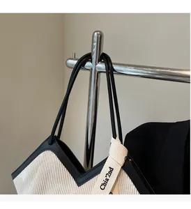 Detail of minimalist corduroy tote with black leather trim and Chia'2nd ribbon tag
