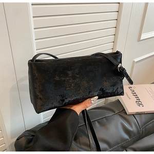 Close-up of vintage black distressed texture and silver buckle on the stylish handbag
