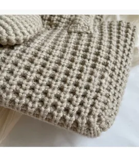 Détail macro de la texture gaufrée beige d'un sac seau élégant fait main pour femme