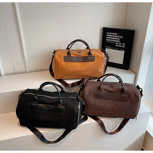 Three travel duffle bags in yellow, brown, and black with adjustable straps and texture