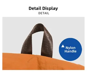 Close-up of the durable brown nylon top handle stitched on an orange travel backpack