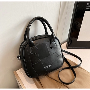 Close-up of black quilted leather handbag with elegant handles and fine stitching details