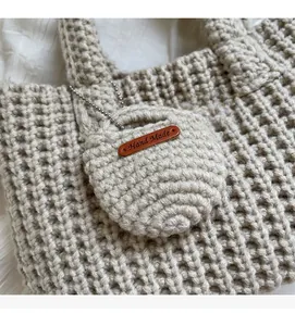 Détail d'un sac à main en maille avoine avec étiquette en cuir fait main et texture