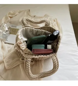 Détail de l'intérieur du sac en tricot fait main avec doublure à cordon et objets