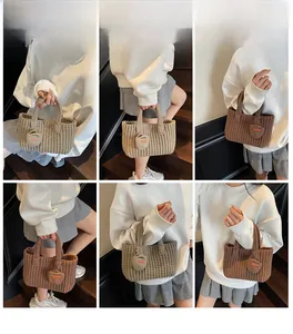 Détail de sacs fourre-tout tricotés main en kaki et marron foncé avec pendentifs ronds