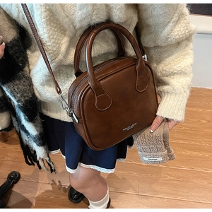 Detail view of dark brown retro crossbody bag with grid pattern and winter accessories