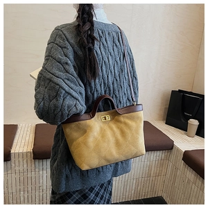Detail of mustard yellow suede tote with diamond quilting and dark brown leather handle