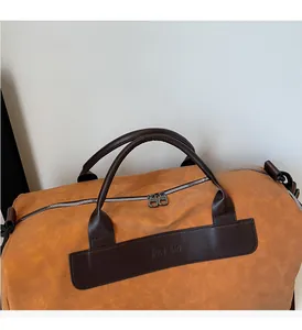 Close-up of textured leather gym bag showing reinforced handles and brand logo