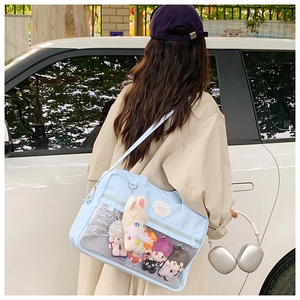 Scatto esterno di una borsa ita in tela azzurra con peluche e tracolla regolabile