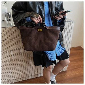 Detail of vintage brown suede tote bag with diamond quilting and gold twist lock