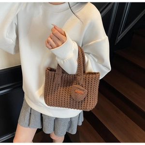 Detail of handmade brown woven bucket bag with leather heart charm and Hand Made tag