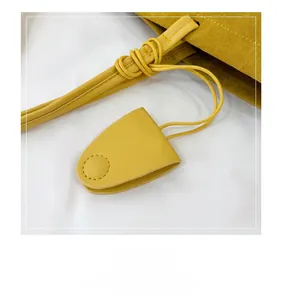 Detail of bright yellow frosted pouch with smooth leather drawstring and fine stitching