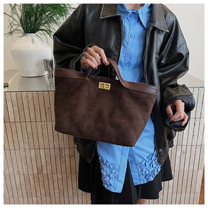 Detail of vintage brown suede tote bag with diamond stitching and golden twist lock closure