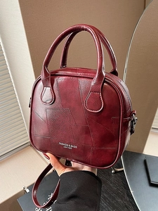 Chic burgundy patchwork crossbody handbag with textured leather and cylindrical top handle